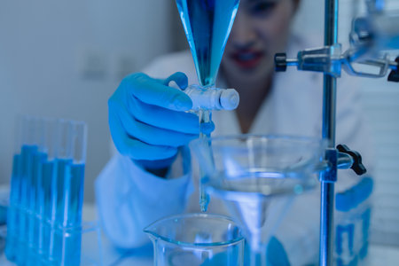 two scientists consult each other while conducting an experiment on a liquid substance in a laboratory, the two chemists exchange experimental data to compile, research, lab,の写真素材