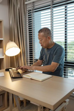 a father spends his retirement years comfortably in his home, a grandfather spends his free time during the day doing various activities in the living roomの写真素材