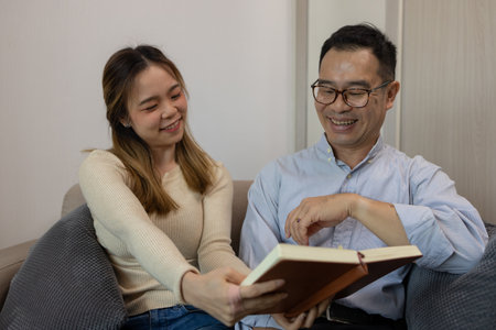 a father and daughter are spending their free time together at home, the daughter spends her weekend visiting her elderly father, a family full of love between a father and daughterの写真素材