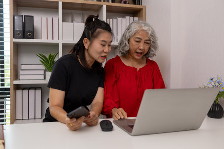a mother and daughter are spending their free time together at home, the daughter spends his weekend visiting his elderly mother, a family full of love between a mother and daughterの写真素材