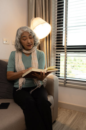 a mother spends her retirement years comfortably in her home, a grandmother spends her free time during the day doing various activities in the living roomの写真素材