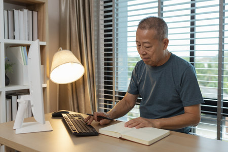 a father spends his retirement years comfortably in his home, a grandfather spends his free time during the day doing various activities in the living roomの写真素材