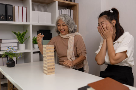 a mother and daughter are spending their free time together at home, the daughter spends his weekend visiting his elderly mother, a family full of love between a mother and daughterの写真素材