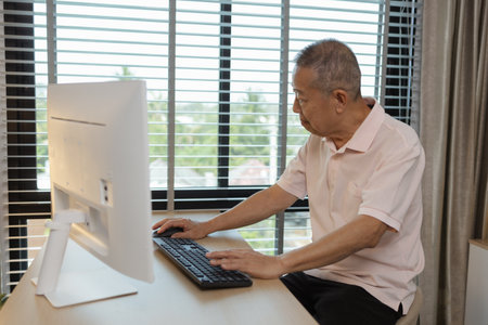 a father spends his retirement years comfortably in his home, a grandfather spends his free time during the day doing various activities in the living roomの写真素材
