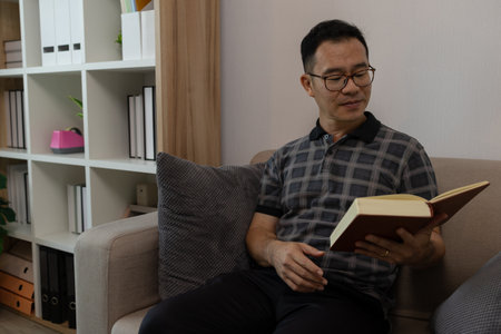 a father spends his retirement years comfortably in his home, a grandfather spends his free time during the day doing various activities in the living roomの写真素材