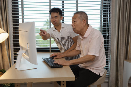 a father and son are spending their free time together at home, the son spends his weekend visiting his elderly father, a family full of love between a father and sonの写真素材