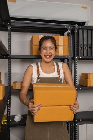 a packer checks the condition of a package before it is delivered to a customer, a small business owner inspects boxes in a warehouse, a storage room filled with shelves and parcelの写真素材