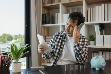 he was stressed because many monthly bills were coming but his total income was not enough to cover all his expenses, he was stressed out calculating the savings to pay off the invoices he receivedの写真素材