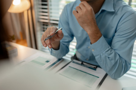 the company's auditing staff is checking the documents for accuracy in the office, businessman is explaining information in a document to his partner, graph, entrepreneur, marketingの写真素材