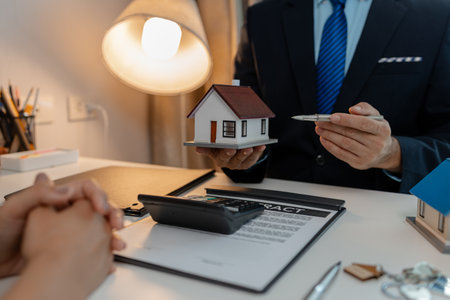 staff is explaining the information about the house lease contract documents to the buyer, the buyer signs the house lease agreement acknowledgment contract with the staff to transfer the ownershipの写真素材