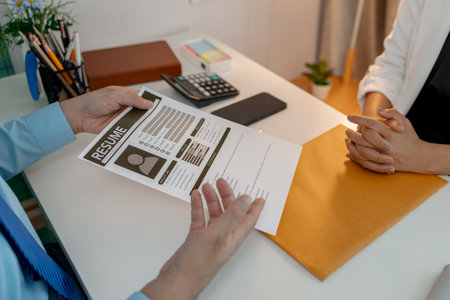 the head of human resources at an accounting firm is interviewing a candidate for a marketing position, resume, recruitment, hr, job interview, he submits his resume to the HR department in the officeの写真素材