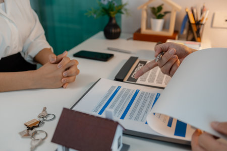 the staff is explaining information about home insurance documents to the buyers, when buying a house you must also buy home insurance for the safety of the property, investmentの写真素材