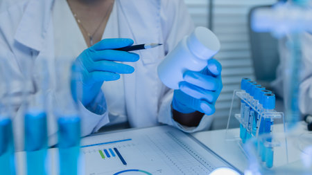 a female chemist is testing various liquid compounds in a lab, a scientist is doing research on the development, she wears a lab coat when she works in laboratory, test tube, scientific equipmentの写真素材