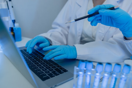 two scientists consult each other while conducting an experiment on a liquid substance in a laboratory, the two chemists exchange experimental data to compile, research, lab,の写真素材