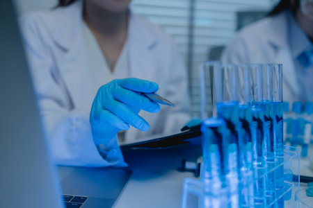 a female chemist is testing various liquid compounds in a lab, a scientist is doing research on the...