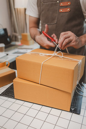 an employee is packing products into boxes to prepare for shipping to customers, a small online business owner is checking boxes for accuracy before shipping to customers, parcel,の写真素材
