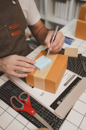 a small online business owner is checking boxes for accuracy before shipping to customers, parcel, an employee is packing products into boxes to prepare for shipping to customersの写真素材