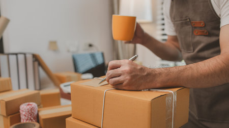 he is checking the boxes in the packing room, a small business owner is preparing boxes to ship to customers, product, e-business, entrepreneurs in online sales and export businessesの写真素材