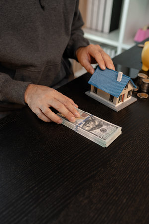 a man uses his savings to buy his dream home, this man plans his finances to buy a home, he uses his savings to buy a home as an investment, financial, money, property, paymentの写真素材