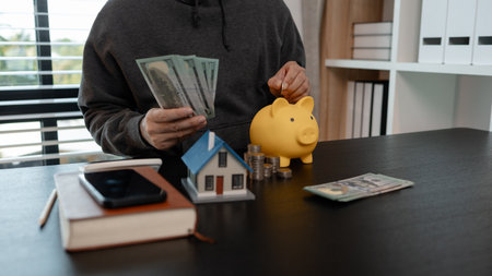 a man uses his savings to buy his dream home, this man plans his finances to buy a home, he uses his savings to buy a home as an investment, financial, money, property, paymentの写真素材
