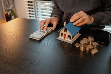 a man uses his savings to buy his dream home, this man plans his finances to buy a home, he uses his savings to buy a home as an investment, financial, money, property, paymentの写真素材