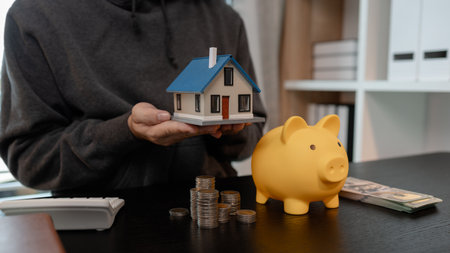 a man uses his savings to buy his dream home, this man plans his finances to buy a home, he uses his savings to buy a home as an investment, financial, money, property, paymentの写真素材