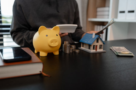 a man is calculating the money from his savings account to buy a house, this man is calculating his finances to plan for buying a house, financial, calculate, income, investmentの写真素材