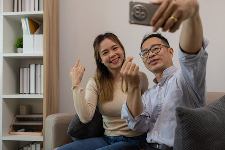 a father and daughter are spending their free time together at home, the daughter spends her weekend visiting her elderly father, a family full of love between a father and daughterの写真素材