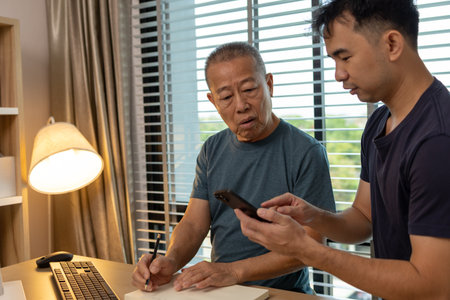 a father and son are spending their free time together at home, the son spends his weekend visiting his elderly father, a family full of love between a father and sonの写真素材