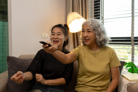 a mother and daughter are spending their free time together at home, the daughter spends his weekend visiting his elderly mother, a family full of love between a mother and daughterの写真素材