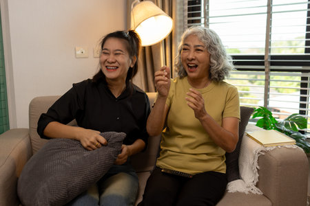 a mother and daughter are spending their free time together at home, the daughter spends his weekend visiting his elderly mother, a family full of love between a mother and daughterの写真素材