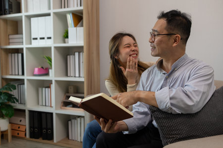 a father and daughter are spending their free time together at home, the daughter spends her weekend visiting her elderly father, a family full of love between a father and daughterの写真素材