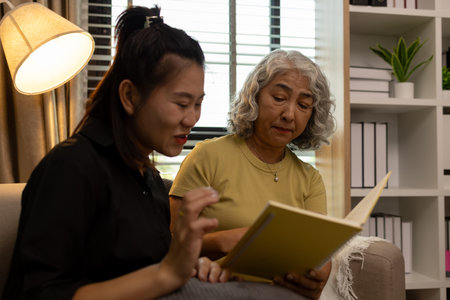a mother and daughter are spending their free time together at home, the daughter spends his weekend visiting his elderly mother, a family full of love between a mother and daughterの写真素材