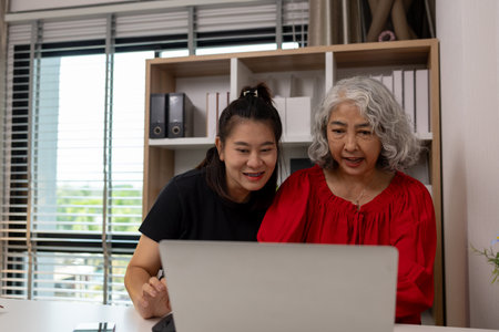 a mother and daughter are spending their free time together at home, the daughter spends his weekend visiting his elderly mother, a family full of love between a mother and daughterの写真素材