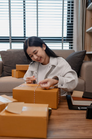she is packing parcel to send to all customers, this entrepreneur own a small business, sme, selling...