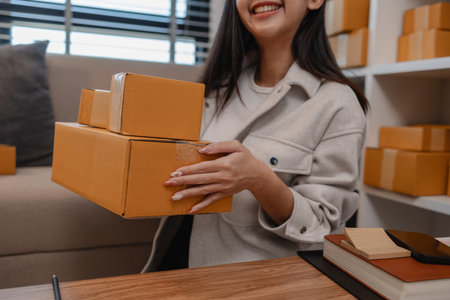 she is packing parcel to send to all customers, this entrepreneur own a small business, sme, selling...