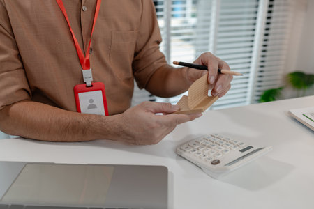 an accountant is working on company's number in the office, this employee works in account...