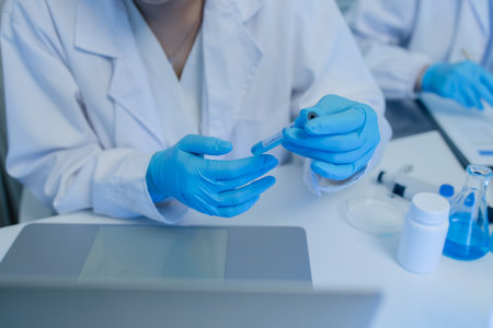 a female chemist is testing various liquid compounds in a lab, a scientist is doing research on the...
