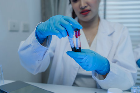 a female chemist is testing various liquid compounds in a lab, a scientist is doing research on the development, she wears a lab coat when she works in laboratory, test tube, scientific equipmentの写真素材