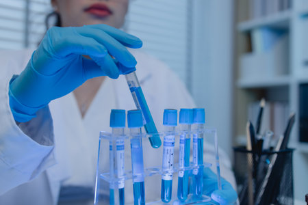 a female scientist is working in lab, a chemist tests liquid sample in science laboratory, she wears...