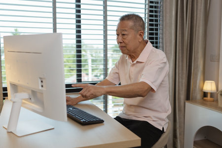 a father spends his retirement years comfortably in his home, a grandfather spends his free time during the day doing various activities in the living roomの写真素材