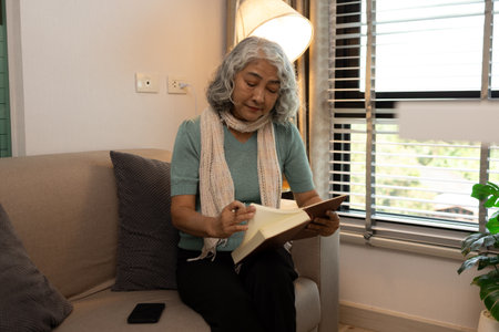 a mother spends her retirement years comfortably in her home, a grandmother spends her free time during the day doing various activities in the living roomの写真素材