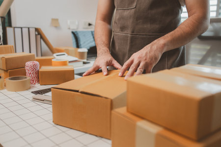 a small online business owner is checking boxes for accuracy before shipping to customers, parcel,...