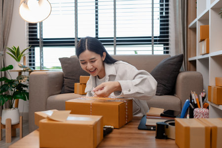 she is packing parcel to send to all customers, this entrepreneur own a small business, sme, selling...