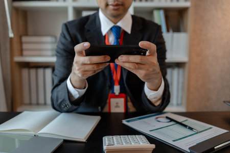 a businessman woks with a foreign company and uses a smartphone to help send and receive...