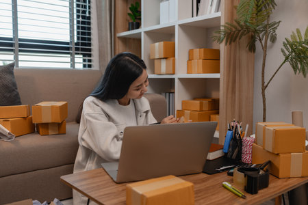this businesswoman own a small business, sme, she is working in online business to sell her product, a lot of parcel, package, an entrepreneur is working on the parcel before deliver to customerの写真素材