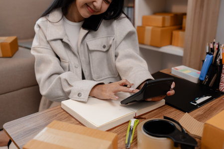 this businesswoman own a small business, sme, she is working in online business to sell her product, a lot of parcel, package, an entrepreneur is working on the parcel before deliver to customerの写真素材