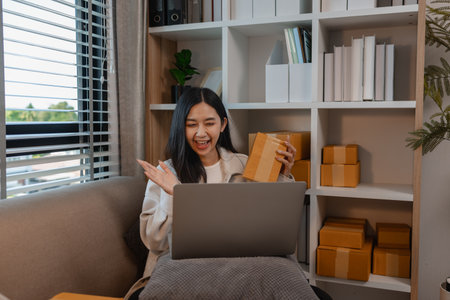 she is running her small business, this entrepreneur is live streaming to sell product, parcel, sme, she want to be a businesswoman, selling product online, streaming to talk to online customerの写真素材