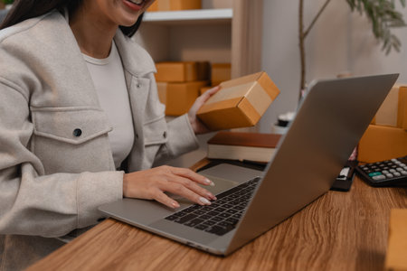 this businesswoman own a small business, sme, she is working in online business to sell her product, a lot of parcel, package, an entrepreneur is working on the parcel before deliver to customerの写真素材