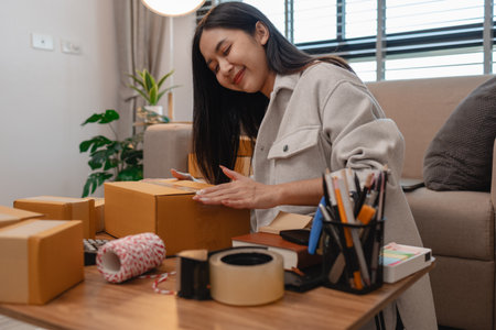 she is packing parcel to send to all customers, this entrepreneur own a small business, sme, selling...